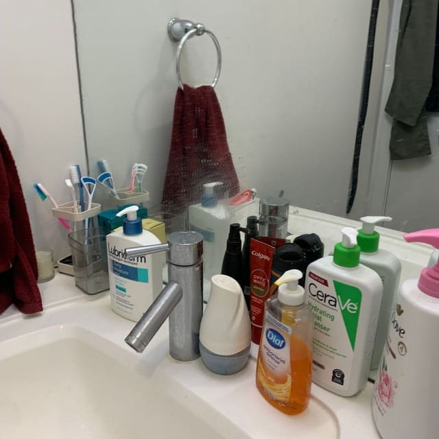 A cleaned bathroom with a wiped sink, mirror and fixtures